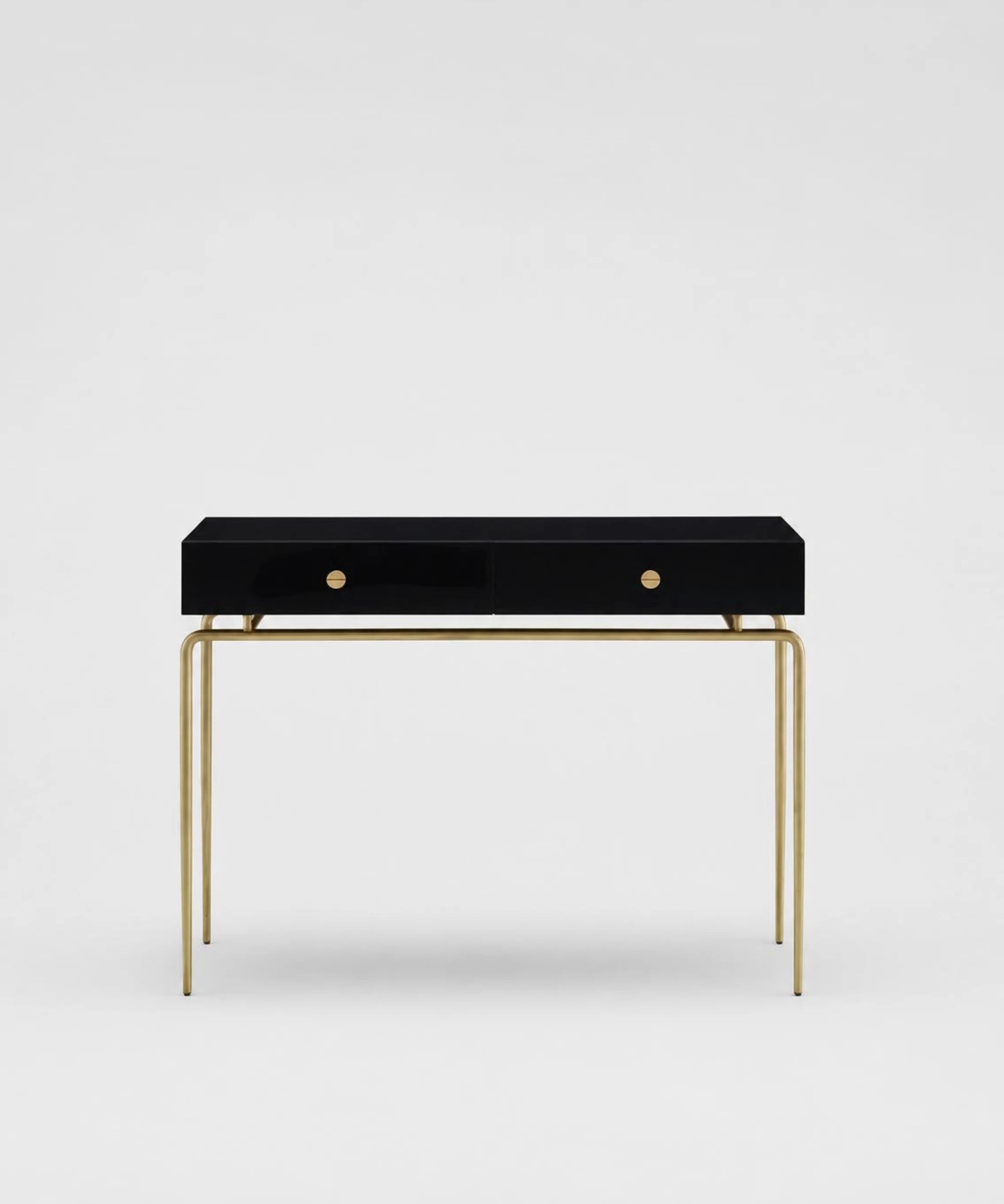 Ligne Roset Débourgeoisée consolle rettangolare con base in acciaio finitura ottonata spazzolata opaca cassettiera in MDF laccato nero brillante con due cassetti soft close vista frontale su sfondo neutro