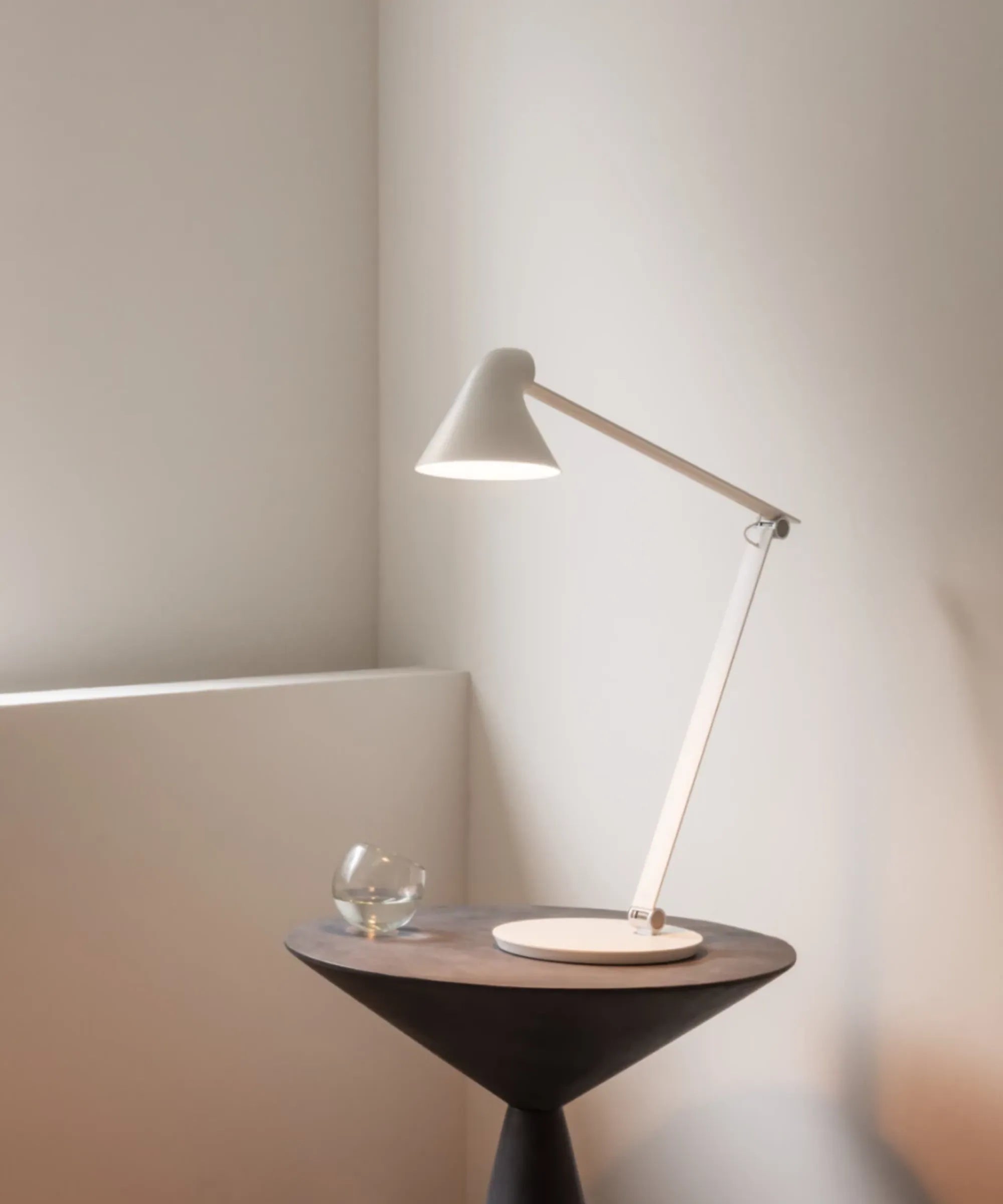 Lampada da tavolo Louis Poulsen NJP bianca design Nendo ambientata su tavolino in interno contemporaneo