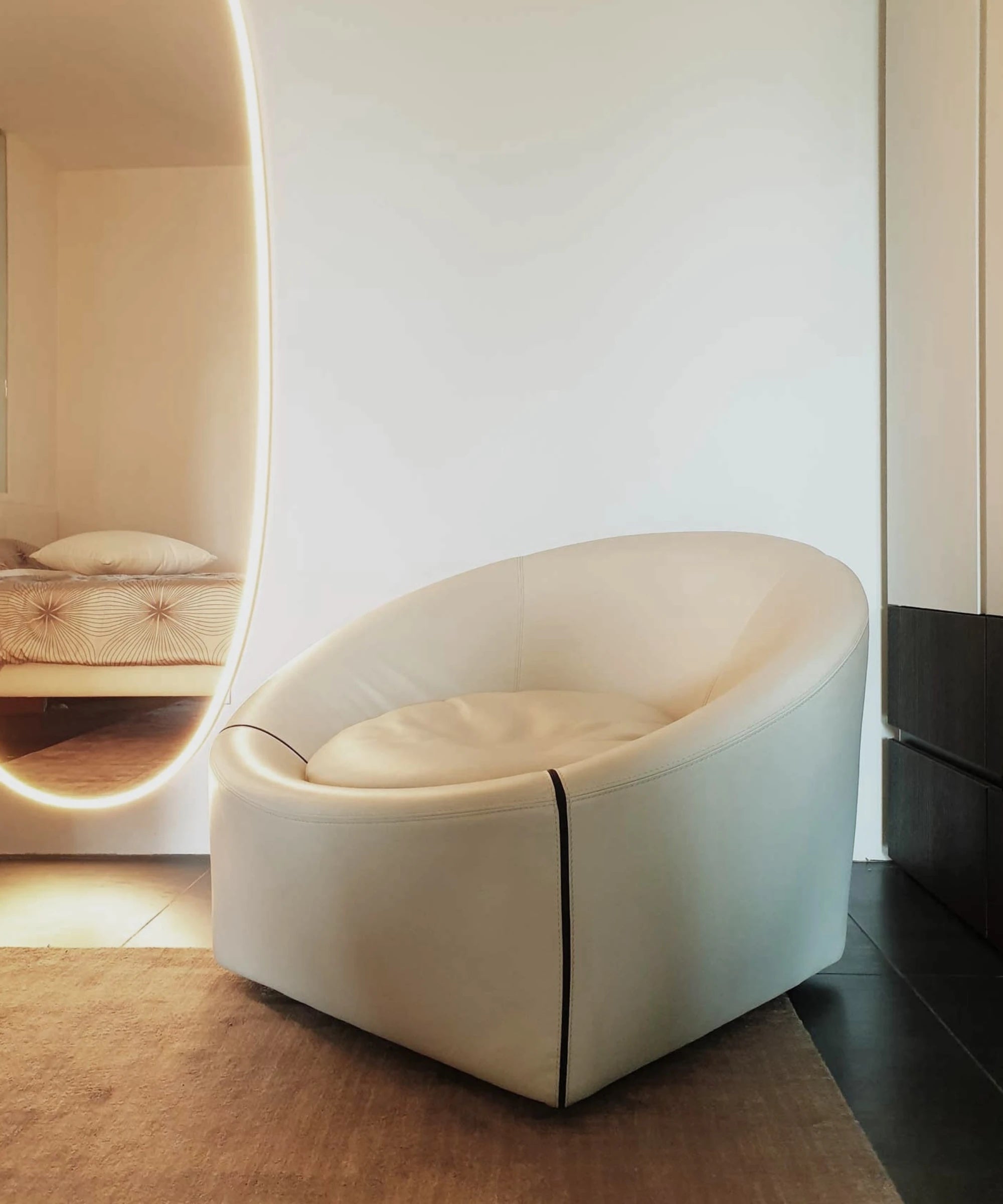 Poltrona lounge Minotti Capri Base design Gordon Guillaumier con seduta imbottita e base in metallo in ambiente living 