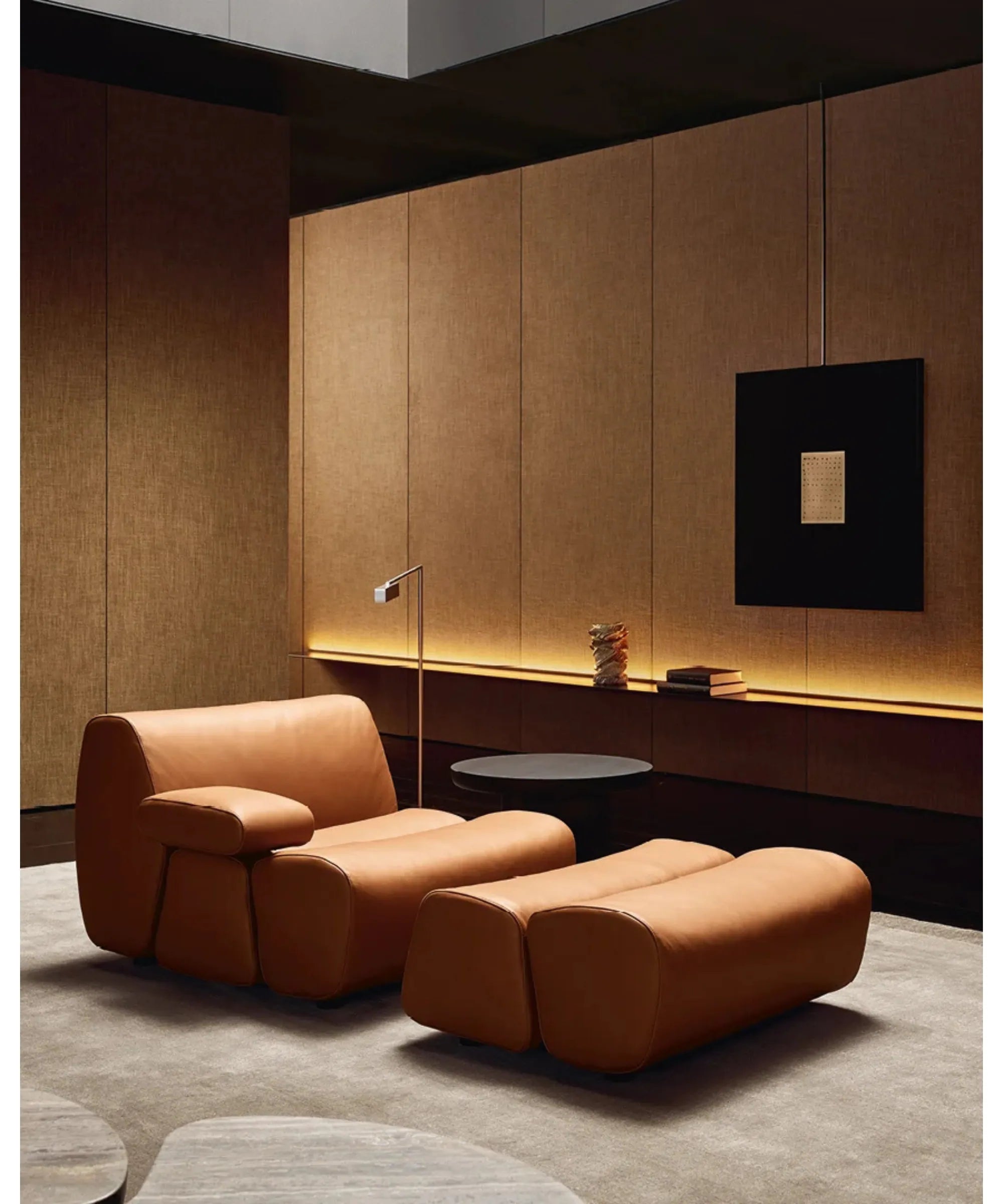 Poltrona lounge con pouf Poliform Ernest in pelle in ambiente living contemporaneo