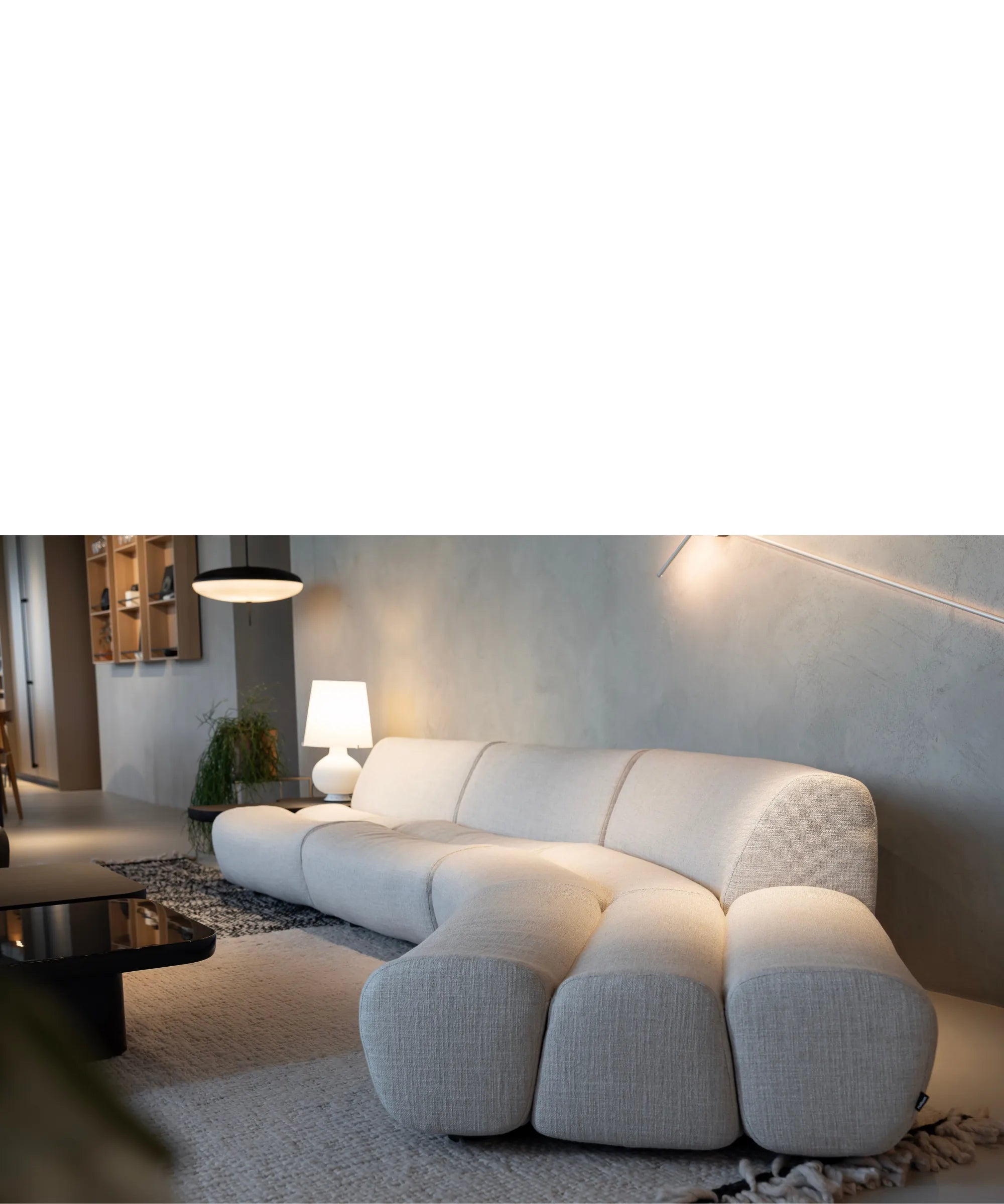 Divano Poliform Ernest in tessuto chiaro inserito in ambiente living minimale